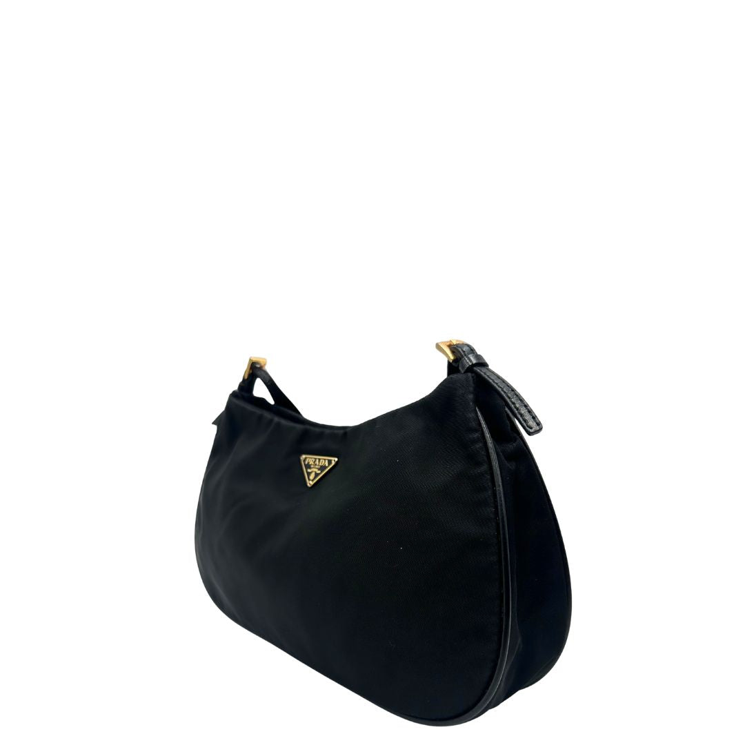 Laterale Borsa Prada in nylon nero con parti metalliche dorate e finiture in pelle tono su tono. Munta di un manico in catena leggermente regolabile con fibbie, e rifinita con classico logo triangolare sul front. Completa di dustbag. Originale, usato, in condizioni ottime. 