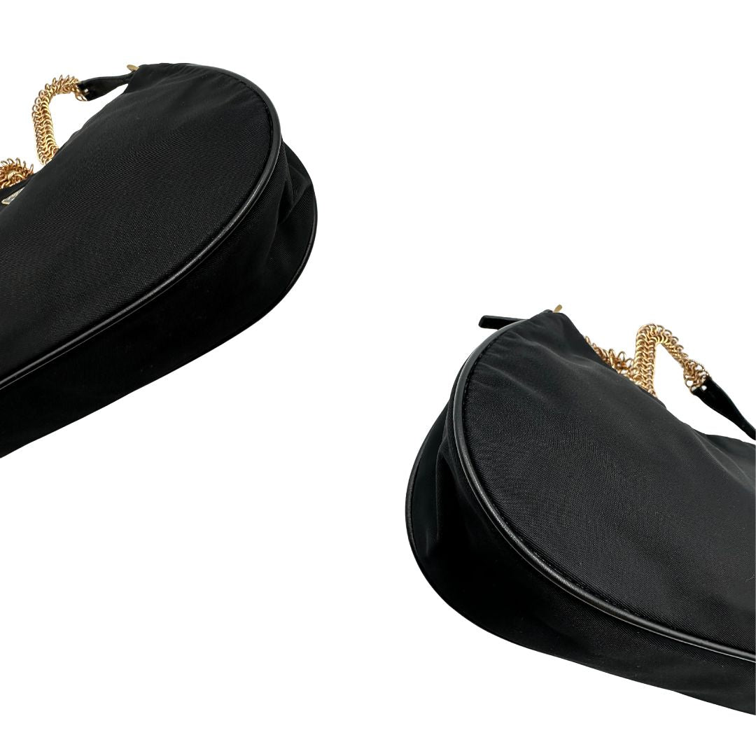 Angoli Borsa Prada in nylon nero con parti metalliche dorate e finiture in pelle tono su tono. Munta di un manico in catena leggermente regolabile con fibbie, e rifinita con classico logo triangolare sul front. Completa di dustbag. Originale, usato, in condizioni ottime. 