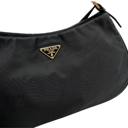 Borsa Prada in nylon nero con parti metalliche dorate e finiture in pelle tono su tono. Munta di un manico in catena leggermente regolabile con fibbie, e rifinita con classico logo triangolare sul front. Completa di dustbag. Originale, usato, in condizioni ottime. 