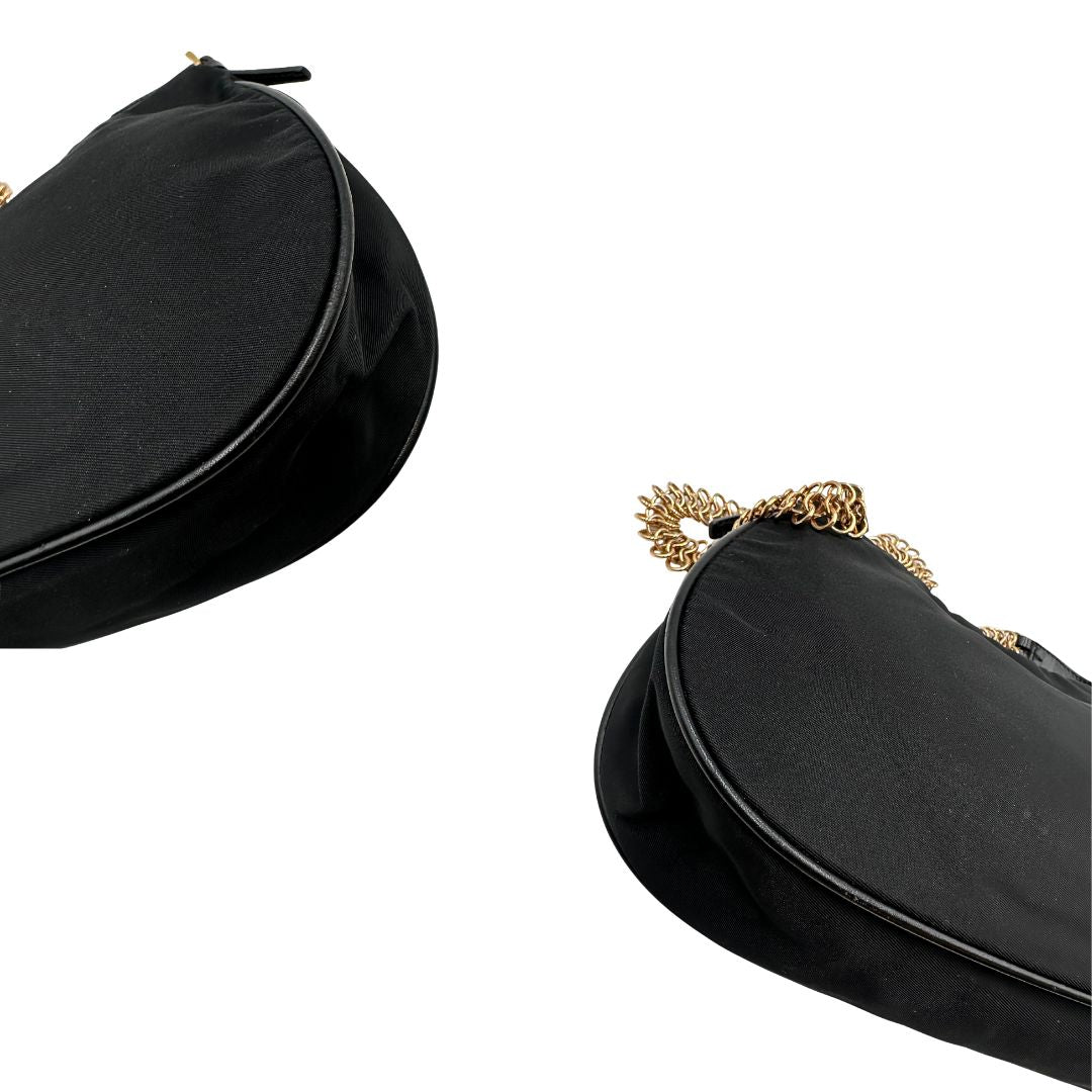 Angoli Borsa Prada in nylon nero con parti metalliche dorate e finiture in pelle tono su tono. Munta di un manico in catena leggermente regolabile con fibbie, e rifinita con classico logo triangolare sul front. Completa di dustbag. Originale, usato, in condizioni ottime. 