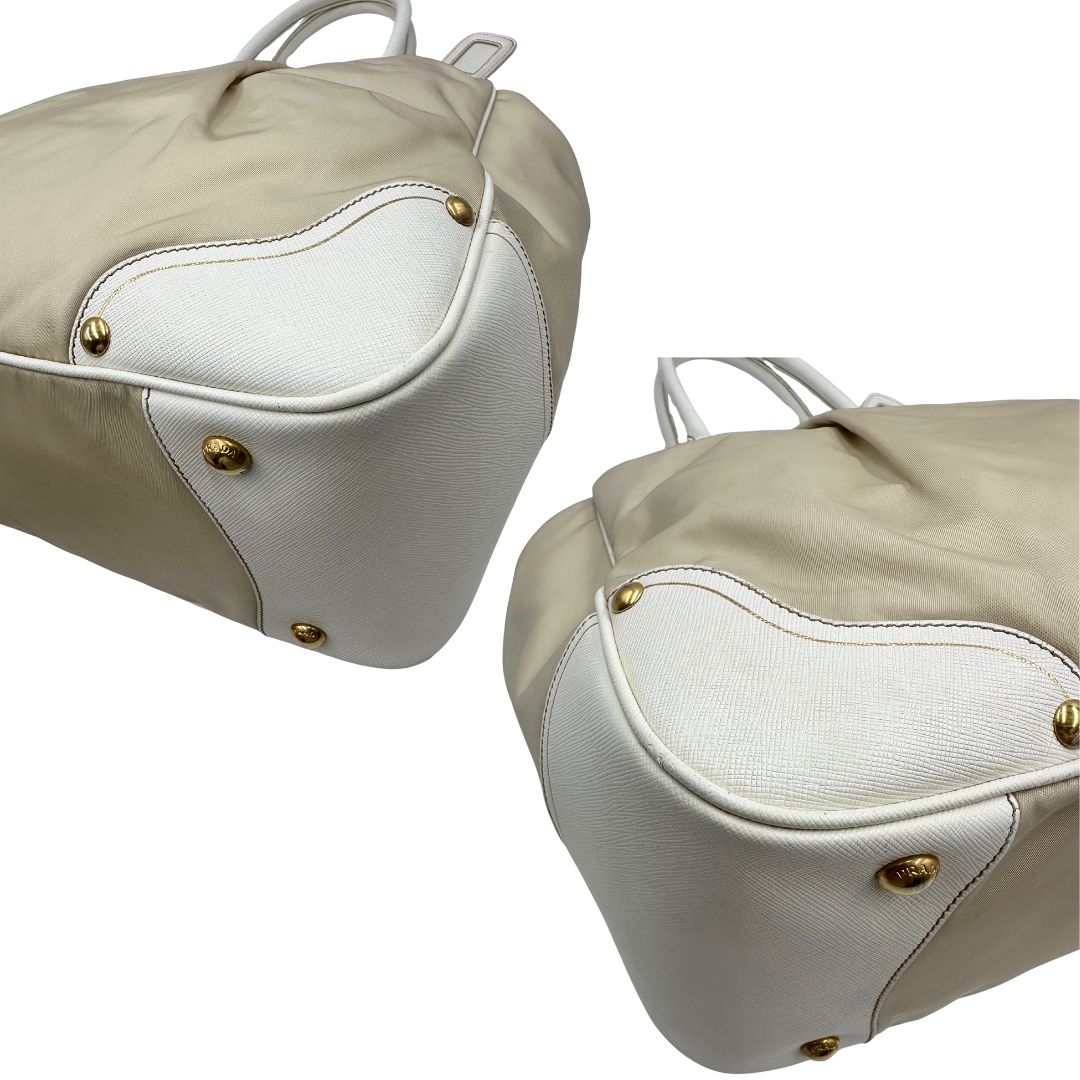 Angoli Borsa Tote Prada in nylon bianco panna con finiture in pelle bianco gesso e parti metalliche dorate. Munita di doppi manici stondati con tag porta address rimovibile. Rifinita con logo lettering al di sotto del manico. Originale, usato, in condizioni ottime. 
