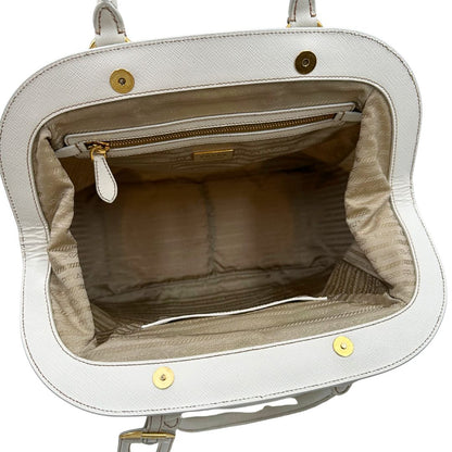 Interno Borsa Tote Prada in nylon bianco panna con finiture in pelle bianco gesso e parti metalliche dorate. Munita di doppi manici stondati con tag porta address rimovibile. Rifinita con logo lettering al di sotto del manico. Originale, usato, in condizioni ottime. 