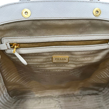 Interno Borsa Tote Prada in nylon bianco panna con finiture in pelle bianco gesso e parti metalliche dorate. Munita di doppi manici stondati con tag porta address rimovibile. Rifinita con logo lettering al di sotto del manico. Originale, usato, in condizioni ottime. 