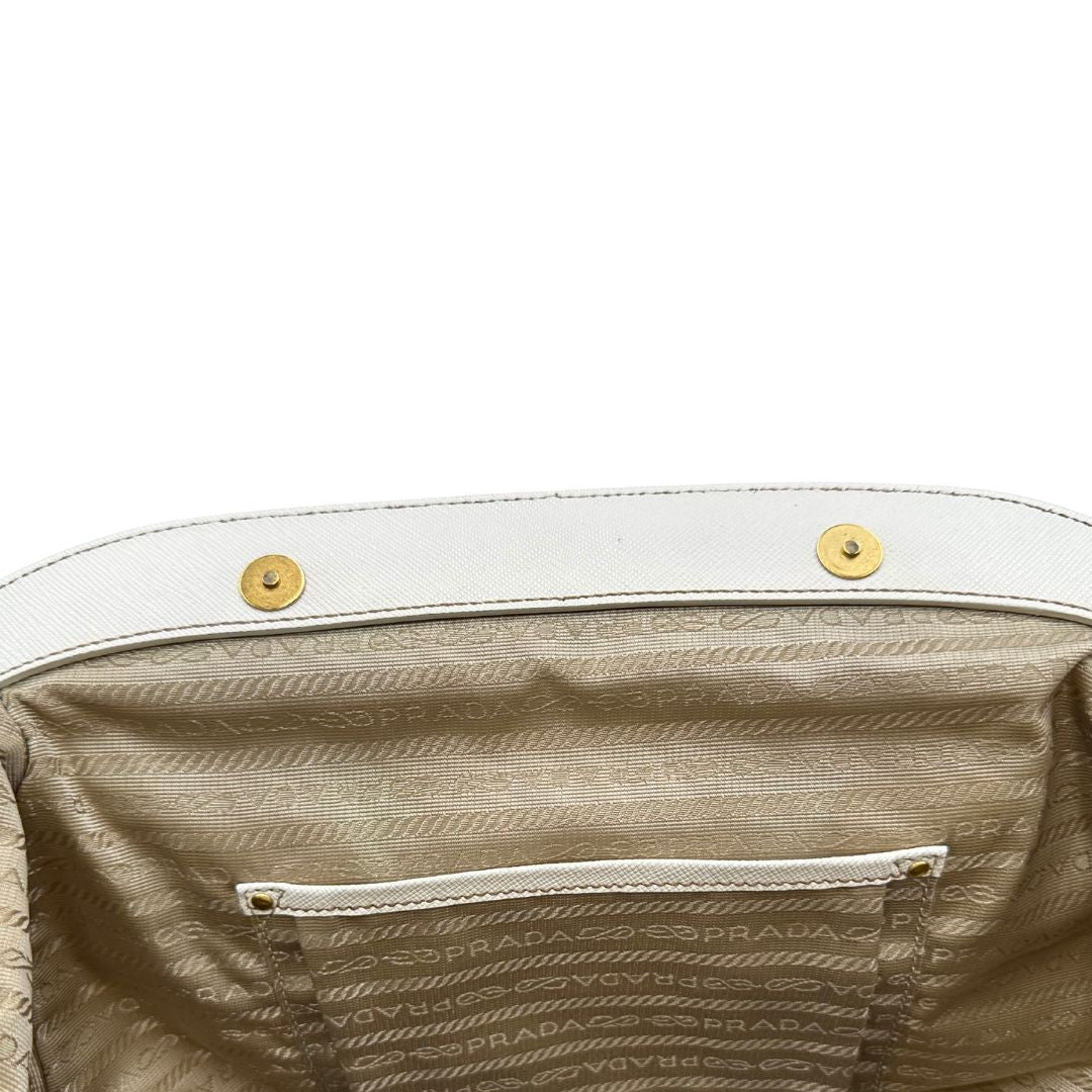 Interno Borsa Tote Prada in nylon bianco panna con finiture in pelle bianco gesso e parti metalliche dorate. Munita di doppi manici stondati con tag porta address rimovibile. Rifinita con logo lettering al di sotto del manico. Originale, usato, in condizioni ottime. 