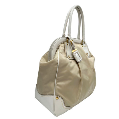 Laterale Borsa Tote Prada in nylon bianco panna con finiture in pelle bianco gesso e parti metalliche dorate. Munita di doppi manici stondati con tag porta address rimovibile. Rifinita con logo lettering al di sotto del manico. Originale, usato, in condizioni ottime. 
