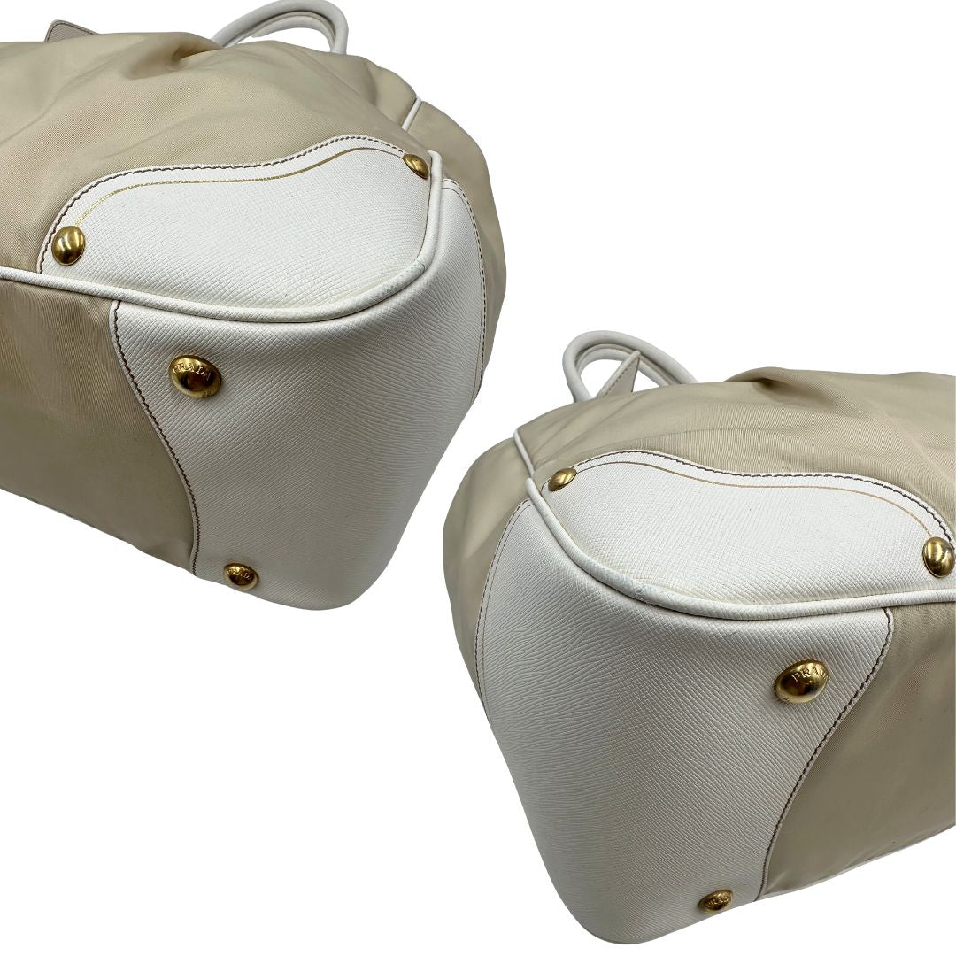 Angoli Borsa Tote Prada in nylon bianco panna con finiture in pelle bianco gesso e parti metalliche dorate. Munita di doppi manici stondati con tag porta address rimovibile. Rifinita con logo lettering al di sotto del manico. Originale, usato, in condizioni ottime. 