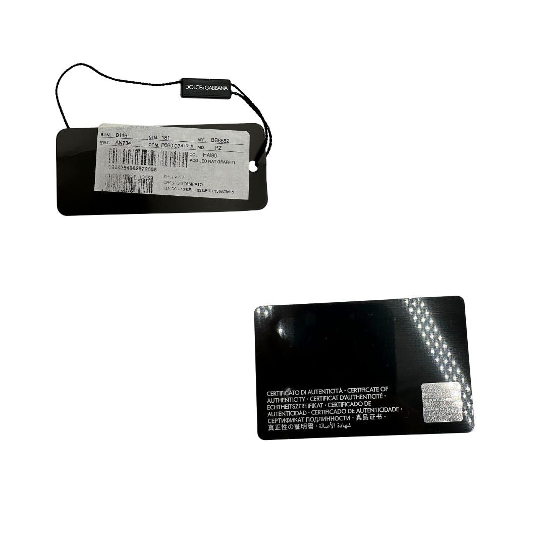 Cartellino e card; Borsa D&G tote Beatrice in canvas con motivo animalier e dettagli graffiti in stile street-art. Il design è arricchito da scritte, cuori e corone, e impreziosita da una striscia centrale rossa. Presenta doppi manici in pelle nera e parti metalliche dorate. Completa di dustbag, cartellino e card d'autenticità. Originale, usato, in condizioni ottime. 