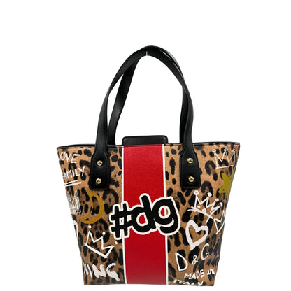 Borsa D&G tote Beatrice in canvas con motivo animalier e dettagli graffiti in stile street-art. Il design è arricchito da scritte, cuori e corone, e impreziosita da una striscia centrale rossa. Presenta doppi manici in pelle nera e parti metalliche dorate. Completa di dustbag, cartellino e card d'autenticità. Originale, usato, in condizioni ottime. 