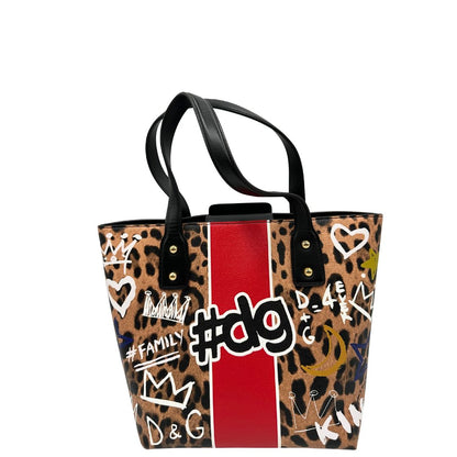 Retro Borsa D&G tote Beatrice in canvas con motivo animalier e dettagli graffiti in stile street-art. Il design è arricchito da scritte, cuori e corone, e impreziosita da una striscia centrale rossa. Presenta doppi manici in pelle nera e parti metalliche dorate. Completa di dustbag, cartellino e card d'autenticità. Originale, usato, in condizioni ottime. 