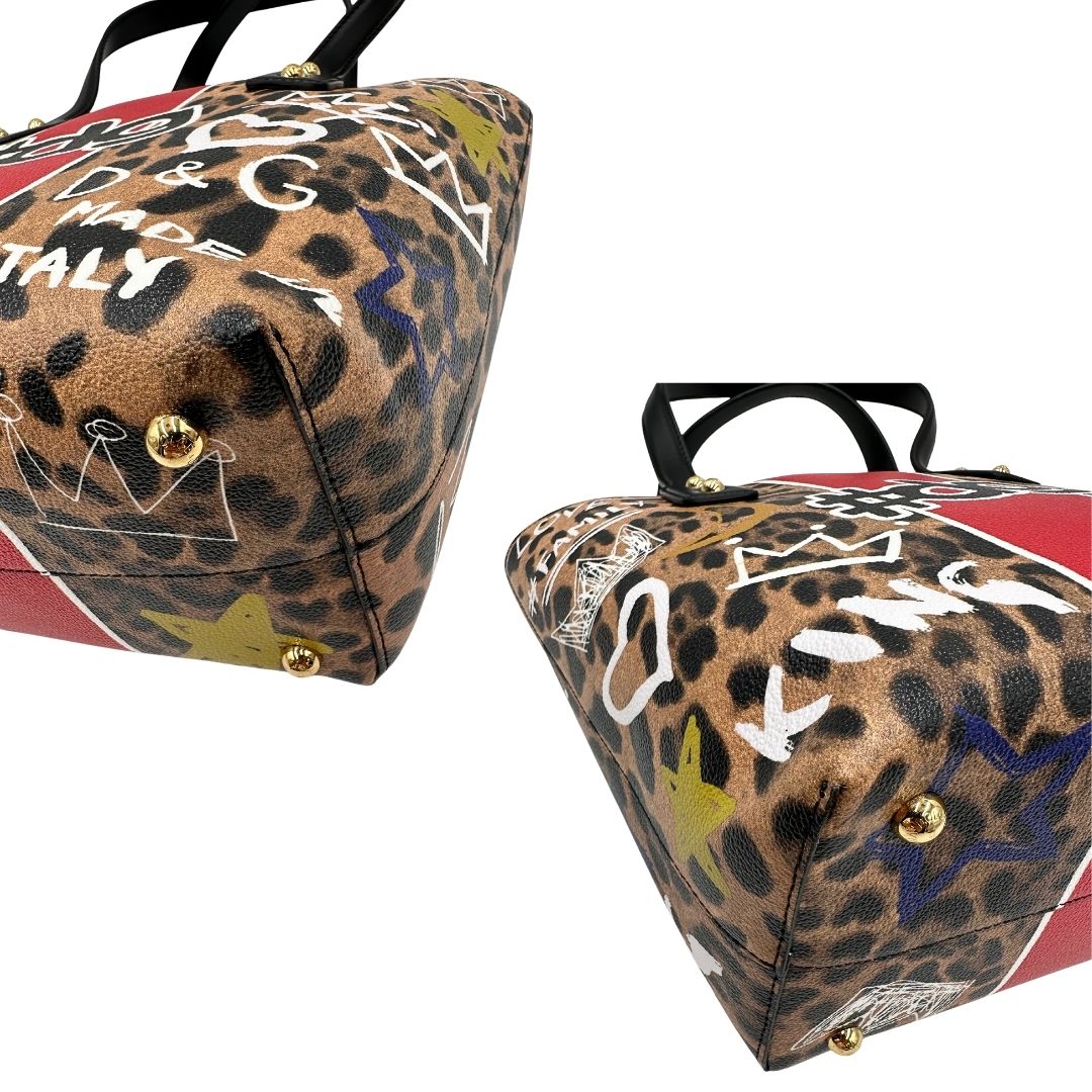 Angoli Borsa D&G tote Beatrice in canvas con motivo animalier e dettagli graffiti in stile street-art. Il design è arricchito da scritte, cuori e corone, e impreziosita da una striscia centrale rossa. Presenta doppi manici in pelle nera e parti metalliche dorate. Completa di dustbag, cartellino e card d'autenticità. Originale, usato, in condizioni ottime. 