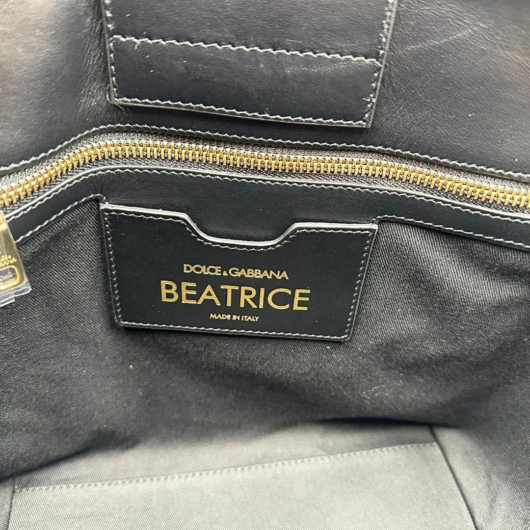 Interno Borsa D&G tote Beatrice in canvas con motivo animalier e dettagli graffiti in stile street-art. Il design è arricchito da scritte, cuori e corone, e impreziosita da una striscia centrale rossa. Presenta doppi manici in pelle nera e parti metalliche dorate. Completa di dustbag, cartellino e card d'autenticità. Originale, usato, in condizioni ottime. 