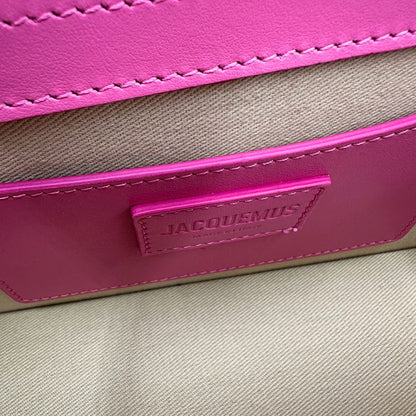 Interno Le Grand Bambino Jacquemus in pelle neon pink con parti metalliche dorate; da portare a mano o a tracolla. Completa di dustbag. Originale, usato, in condizioni ottime. 
