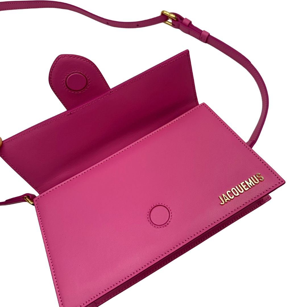 Le Grand Bambino Jacquemus in pelle neon pink con parti metalliche dorate; da portare a mano o a tracolla. Completa di dustbag. Originale, usato, in condizioni ottime. 