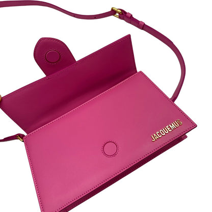 Le Grand Bambino Jacquemus in pelle neon pink con parti metalliche dorate; da portare a mano o a tracolla. Completa di dustbag. Originale, usato, in condizioni ottime. 