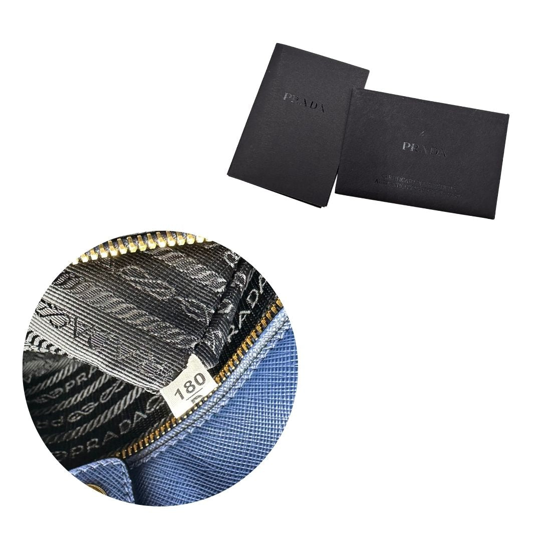 codice Borsa Prada in pelle saffiano blu e nera con parti metalliche dorate; munita di doppi manici stondati e impreziosita da un portachiavi. Completa di dustbag, di lusso, originale, ottime condizoni, usata. 