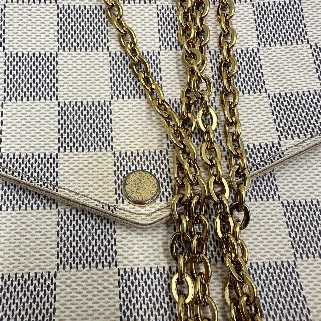 Borsa Louis Vuitton Félicie in canvas Damier Azur con parti metalliche dorate e interno in pelle rosa. Munita di una tracolla in catena amovibile e accessori portacarte, e portamonete estraibili. Originale, usato, in condizioni ottime.