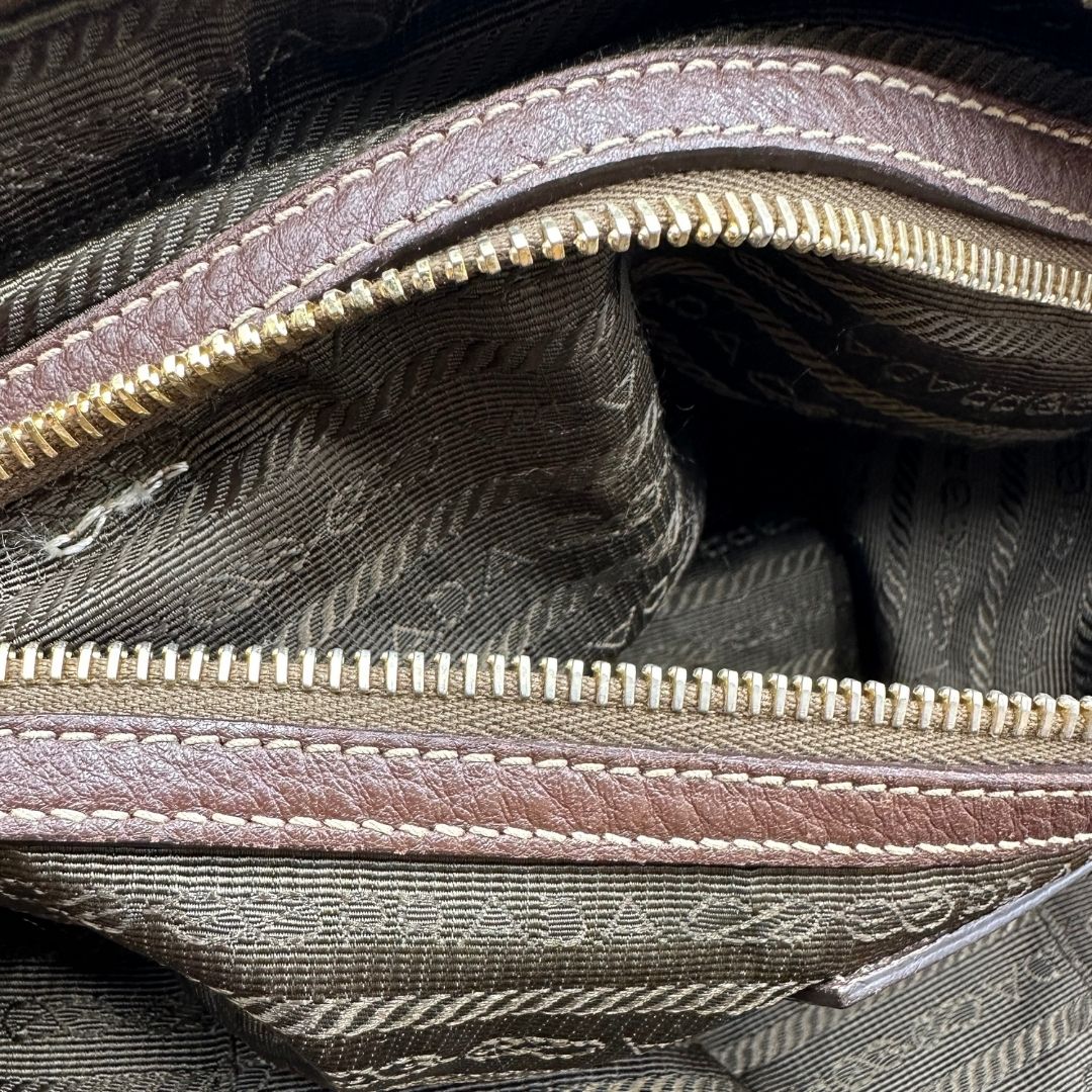interno Borsa Prada in denim con finiture in pelle marroni e parti metalliche dorate; munita di doppi manici e una tracolla amovibile e regolabile, impreziosita da un porta address. Completa di dustbag, di lusso, ottime condizioni, originale.
