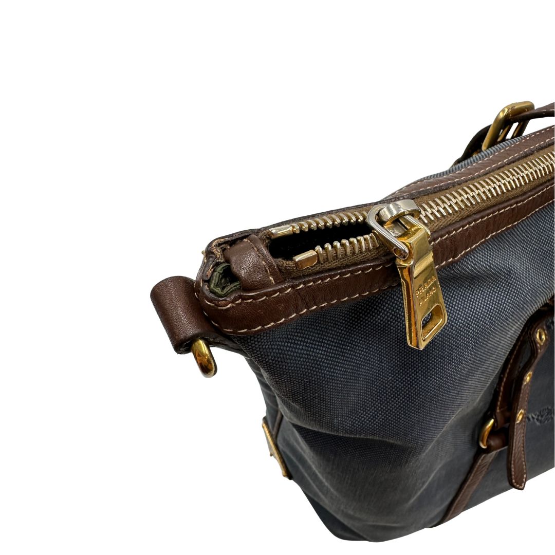 Borsa Prada in denim con finiture in pelle marroni e parti metalliche dorate; munita di doppi manici e una tracolla amovibile e regolabile, impreziosita da un porta address. Completa di dustbag, di lusso, ottime condizioni, originale. 