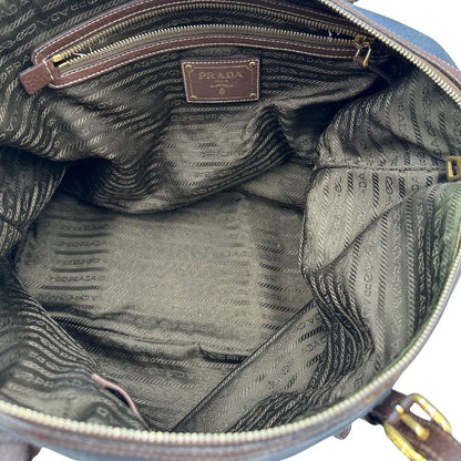 interno Borsa Prada in denim con finiture in pelle marroni e parti metalliche dorate; munita di doppi manici e una tracolla amovibile e regolabile, impreziosita da un porta address. Completa di dustbag, di lusso, ottime condizioni, originale.