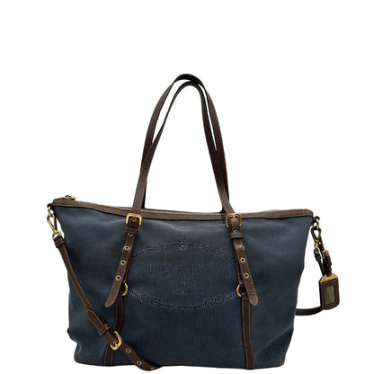 front Borsa Prada in denim con finiture in pelle marroni e parti metalliche dorate; munita di doppi manici e una tracolla amovibile e regolabile, impreziosita da un porta address. Completa di dustbag, di lusso, ottime condizioni, originale. 