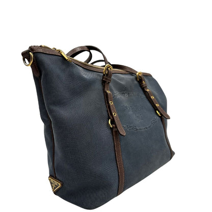 lato Borsa Prada in denim con finiture in pelle marroni e parti metalliche dorate; munita di doppi manici e una tracolla amovibile e regolabile, impreziosita da un porta address. Completa di dustbag, di lusso, ottime condizioni, originale. 