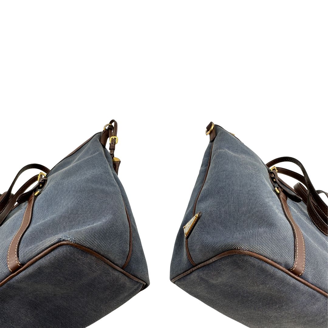 angoli Borsa Prada in denim con finiture in pelle marroni e parti metalliche dorate; munita di doppi manici e una tracolla amovibile e regolabile, impreziosita da un porta address. Completa di dustbag, di lusso, ottime condizioni, originale. 