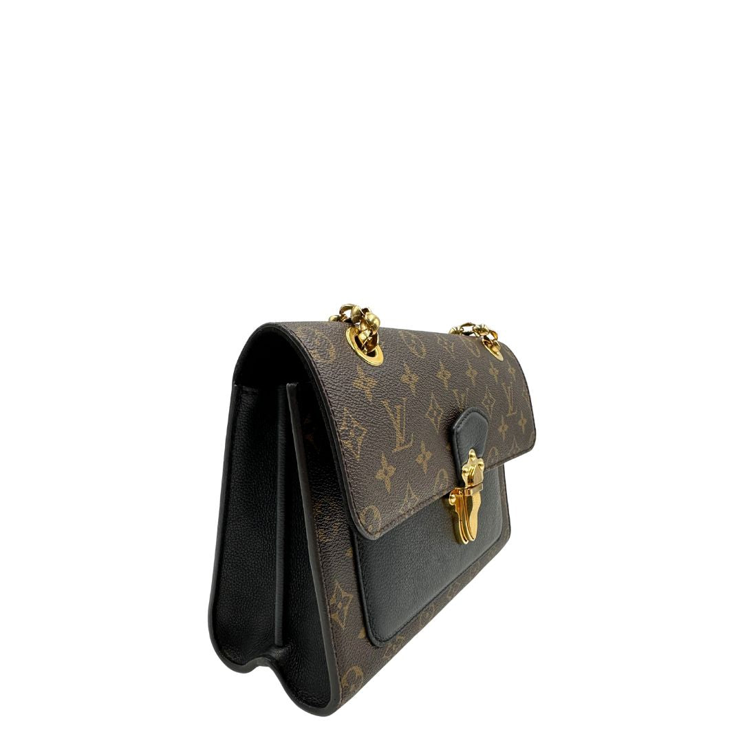 lato Borsa Louis Vuitton Victoire in canvas marrone monogram, finiture in pelle nera e parti metalliche dorate; munita di una tracolla in catena scorrevole. Completa di scatola, di lusso, originale. 