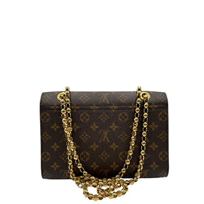 retro Borsa Louis Vuitton Victoire in canvas marrone monogram, finiture in pelle nera e parti metalliche dorate; munita di una tracolla in catena scorrevole. Completa di scatola, di lusso, originale. 