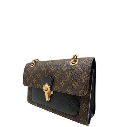 lato Borsa Louis Vuitton Victoire in canvas marrone monogram, finiture in pelle nera e parti metalliche dorate; munita di una tracolla in catena scorrevole. Completa di scatola, di lusso, originale. 