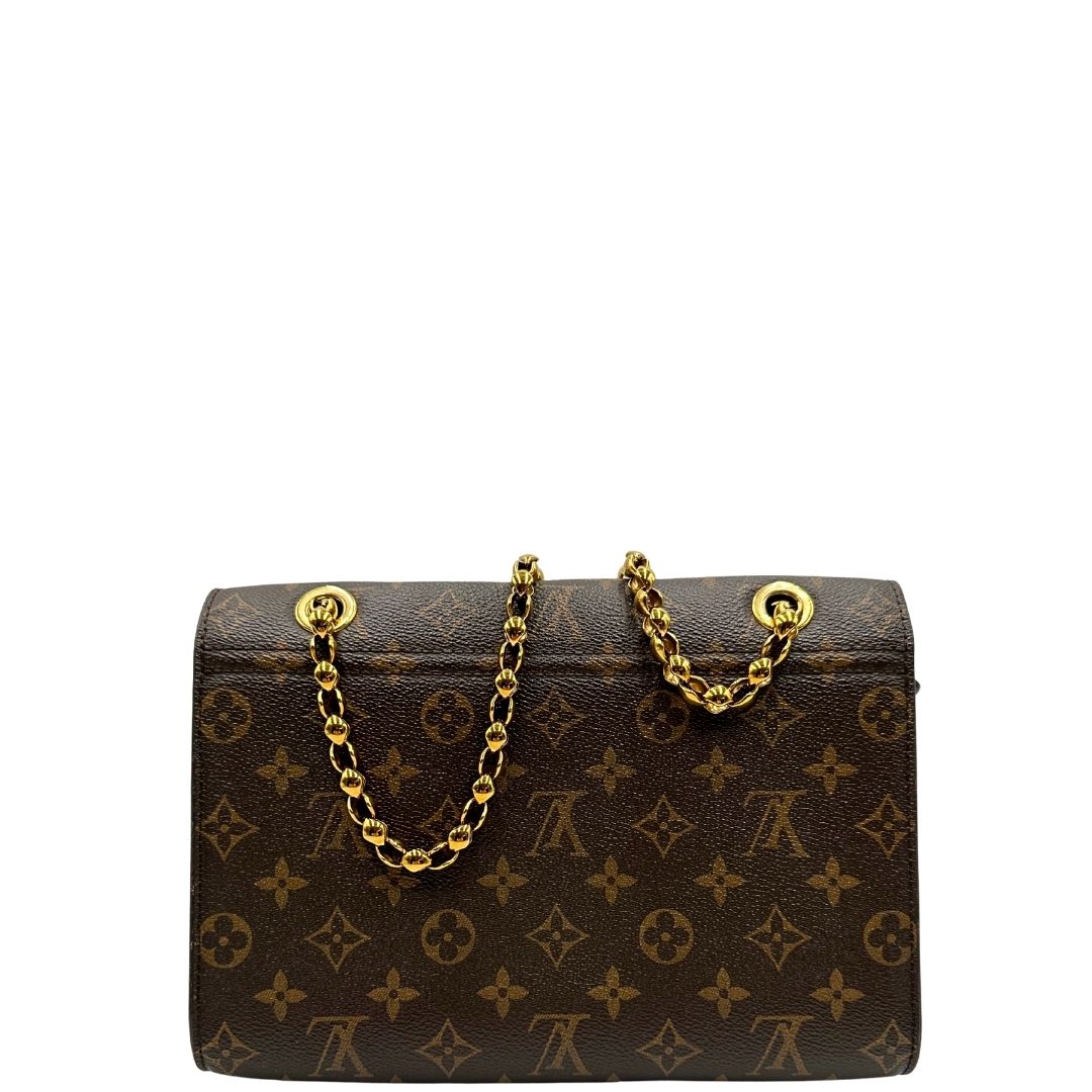 retro Borsa in canvas marrone monogram, finiture nere e parti metalliche dorate; munita di una tracolla in catena scorrevole. Completa di scatola, di lusso, originale, ottime condizioni.