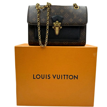 Borsa in canvas marrone monogram, finiture nere e parti metalliche dorate; munita di una tracolla in catena scorrevole. Completa di scatola, di lusso, originale, ottime condizioni. 