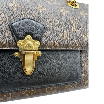 chiusura Borsa in canvas marrone monogram, finiture nere e parti metalliche dorate; munita di una tracolla in catena scorrevole. Completa di scatola, di lusso, originale, ottime condizioni. 