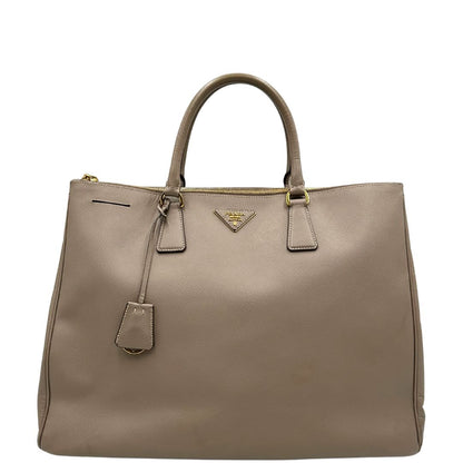 borsa Prada in pelle saffiano color fango con parti metalliche dorate; munita di doppi manici stondati e impreziosita da una clochette portachiavi, di lusso, originale, ottime condizioni.