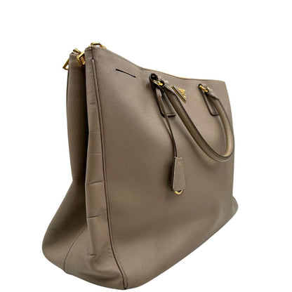 borsa Prada in pelle saffiano color fango con parti metalliche dorate; munita di doppi manici stondati e impreziosita da una clochette portachiavi, di lusso, originale, ottime condizioni.