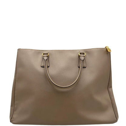 borsa Prada in pelle saffiano color fango con parti metalliche dorate; munita di doppi manici stondati e impreziosita da una clochette portachiavi, di lusso, originale, ottime condizioni.