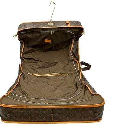 interno Borsa da viaggio in canvas marrone monogram con finiture in vacchetta naturale e parti metalliche dorate; munita di un manico singolo,una tracolla amovibile e regolabile e 5 grucce, di lusso, originale, ottime condizioni. 