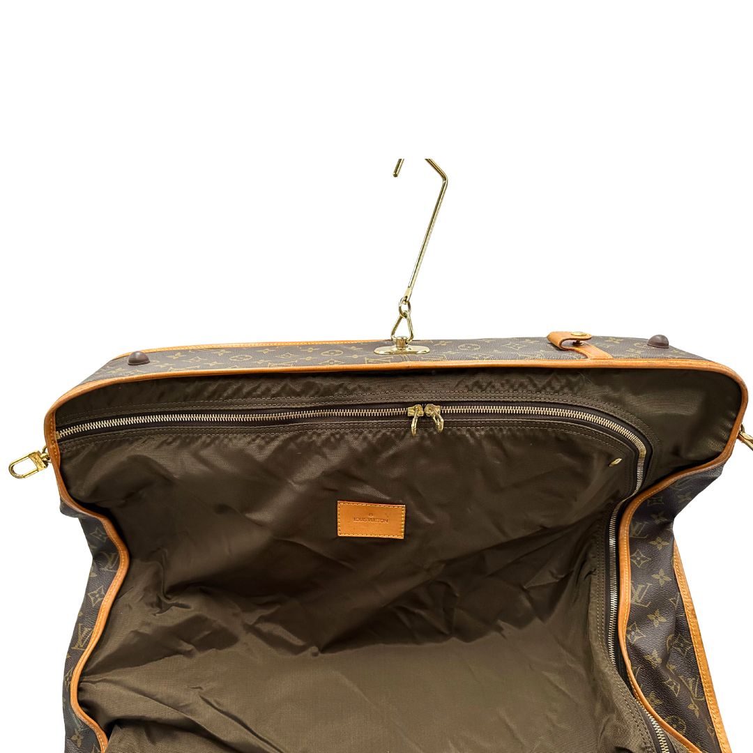 interno Borsa da viaggio in canvas marrone monogram con finiture in vacchetta naturale e parti metalliche dorate; munita di un manico singolo,una tracolla amovibile e regolabile e 5 grucce, di lusso, originale, ottime condizioni. 