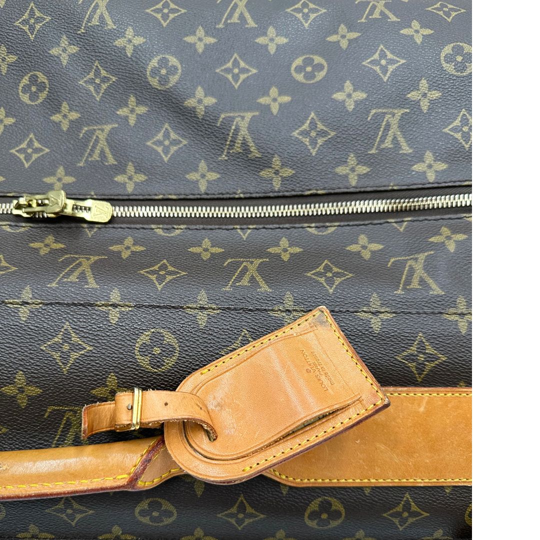 Borsa da viaggio in canvas marrone monogram con finiture in vacchetta naturale e parti metalliche dorate; munita di un manico singolo,una tracolla amovibile e regolabile e 5 grucce, di lusso, originale, ottime condizioni. 