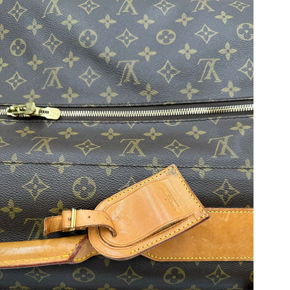 Borsa da viaggio in canvas marrone monogram con finiture in vacchetta naturale e parti metalliche dorate; munita di un manico singolo,una tracolla amovibile e regolabile e 5 grucce, di lusso, originale, ottime condizioni. 