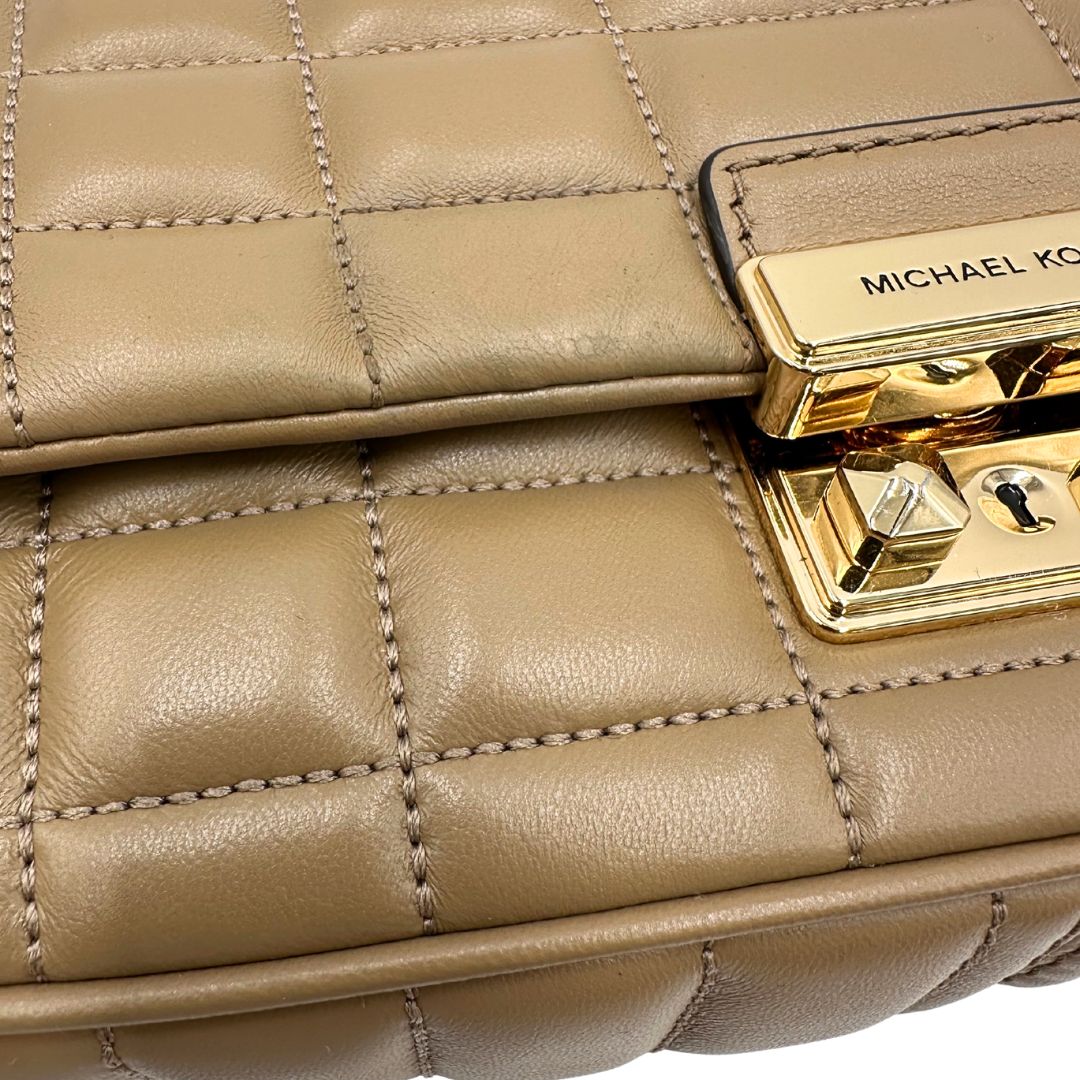 Borsa Michael Kors Tribeca in pelle matelassé écru con parti metalliche dorate. Munita di una tracolla scorrevole in catena con spallacci in pelle. Completa di dustbag. Originale, usato, in condizioni ottime. 