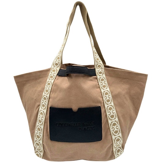 Front di una shopper Coccinelle in cotone beige con dettaglio manici a nastro intessuti in avorio; finiture in pelle nere, da indossare a spalla.