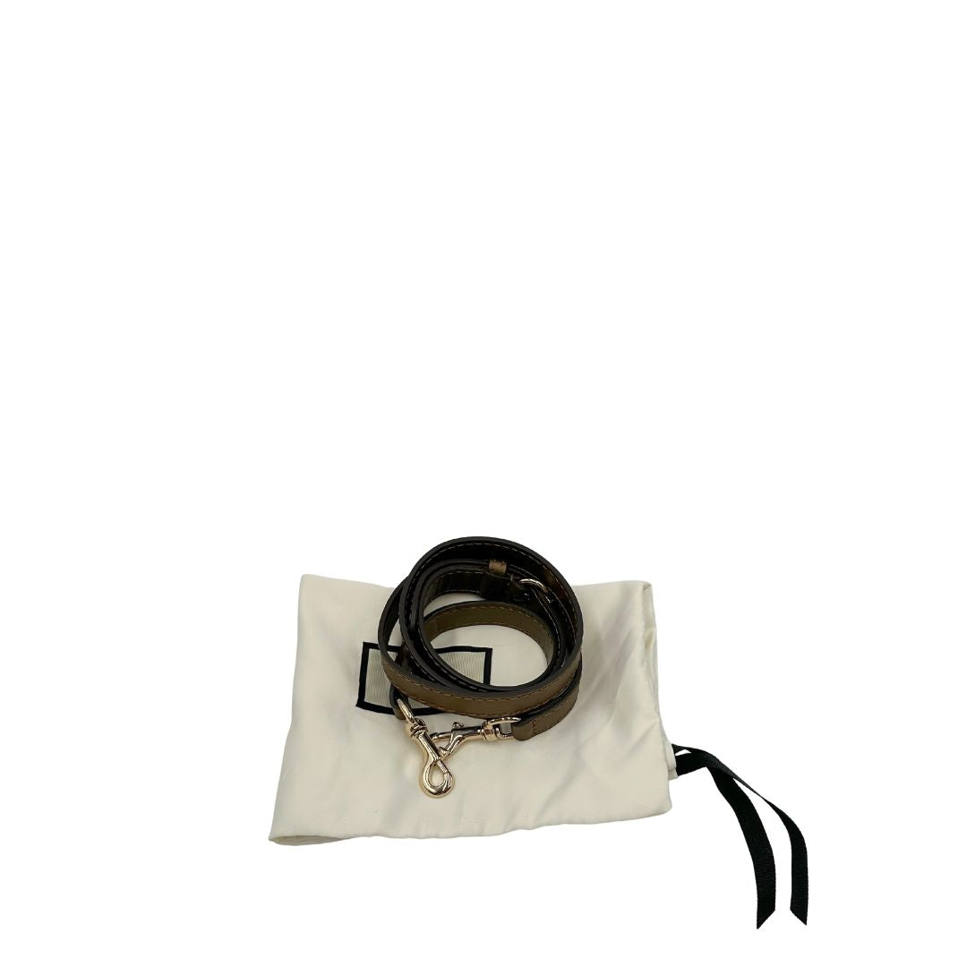 Accessorio Tracolla Gucci regolabile in pelle verde brunastro effetto metallizzato con fibbia e moschettoni in metallo dorato. Completa di sacchetto antipolvere. Originale, usato, in condizioni ottime. 