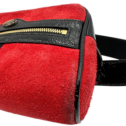 Angoli di un marsupio Gucci Ophidia in pelle scamosciata rossa con finiture in pelle verniciata nera, striscia Web centrale in tessuto blu e rosso, cintura regolabile e amovibile, parti metalliche dorate. Completo di dustbag.