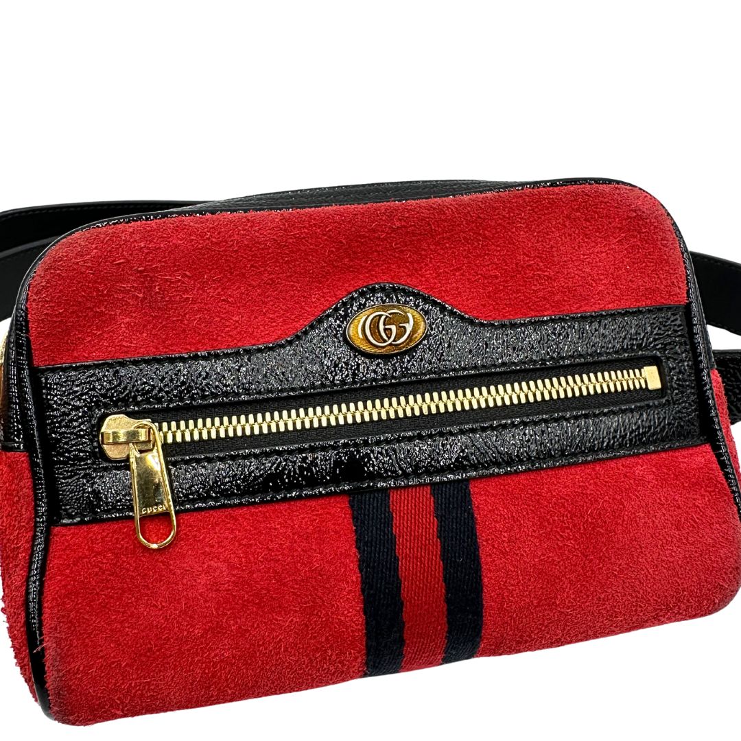Front di un marsupio Gucci Ophidia in pelle scamosciata rossa con finiture in pelle verniciata nera, striscia Web centrale in tessuto blu e rosso, cintura regolabile e amovibile, parti metalliche dorate. Completo di dustbag.