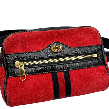 Front di un marsupio Gucci Ophidia in pelle scamosciata rossa con finiture in pelle verniciata nera, striscia Web centrale in tessuto blu e rosso, cintura regolabile e amovibile, parti metalliche dorate. Completo di dustbag.