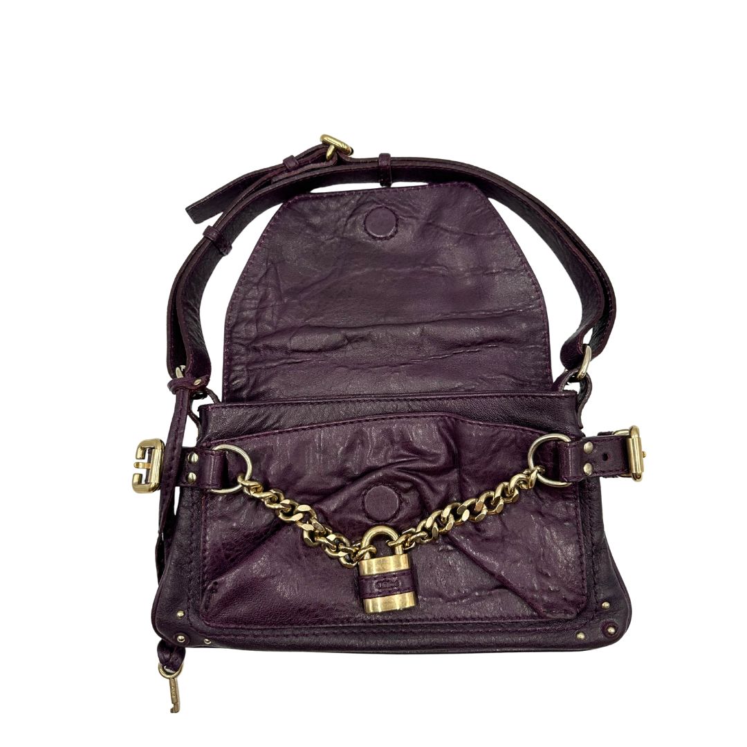 Borsa Chloé Maxi Lock in pelle viola prugna con parti metalliche dorate. Munita di un manico regolabile e impreziosita da una catena sul front con lucchetto. Originale, usato, in condizioni ottime. 