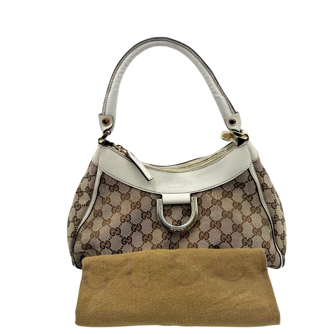 Borsa Gucci Hobo D-Ring in tessuto beige GG con finiture in pelle bianca e parti metalliche dorate. Munita di un manico in pelle stondato, rifinita con dettaglio D-Ring e logo lettering sul front. Completa di dustbag. Originale, usato, in condizioni ottime. 