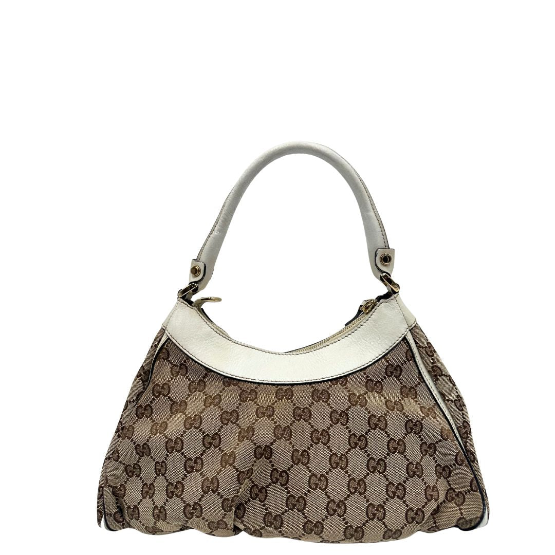 Retro Borsa Gucci Hobo D-Ring in tessuto beige GG con finiture in pelle bianca e parti metalliche dorate. Munita di un manico in pelle stondato, rifinita con dettaglio D-Ring e logo lettering sul front. Completa di dustbag. Originale, usato, in condizioni ottime. 