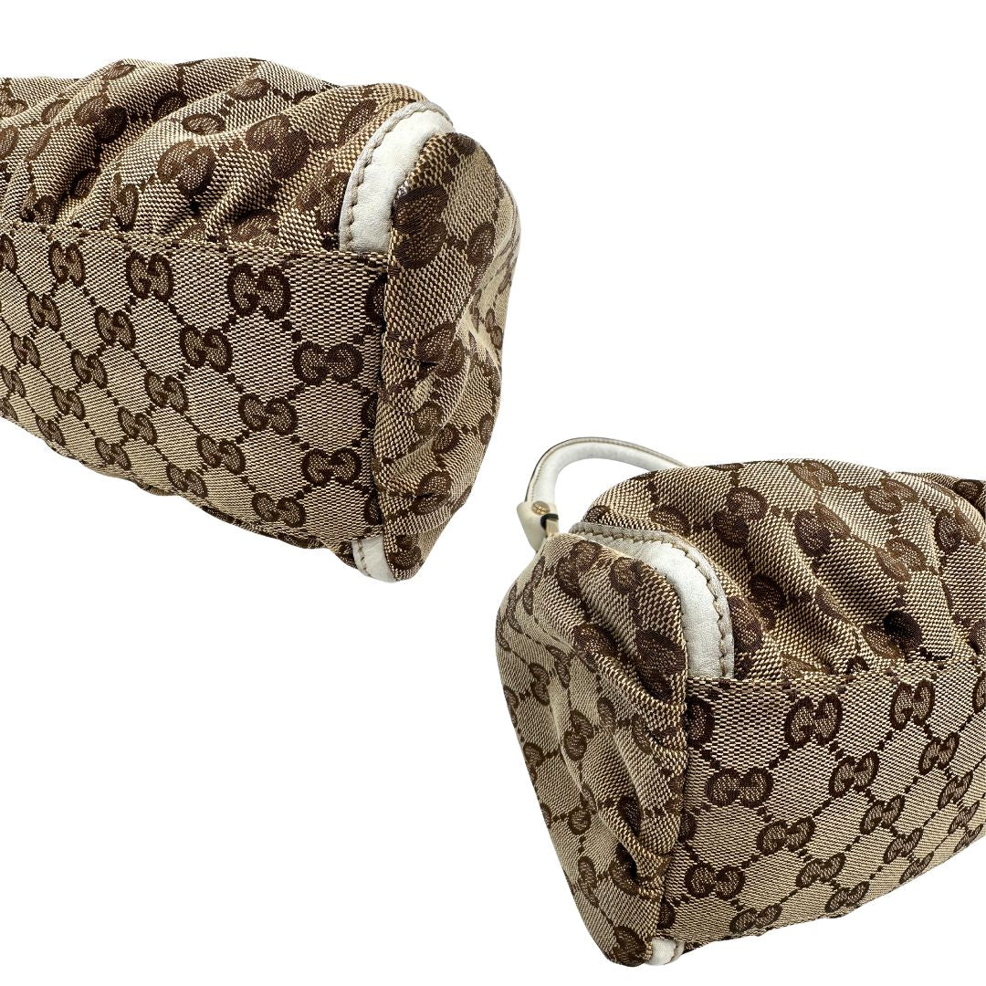 Angoli Borsa Gucci Hobo D-Ring in tessuto beige GG con finiture in pelle bianca e parti metalliche dorate. Munita di un manico in pelle stondato, rifinita con dettaglio D-Ring e logo lettering sul front. Completa di dustbag. Originale, usato, in condizioni ottime. 