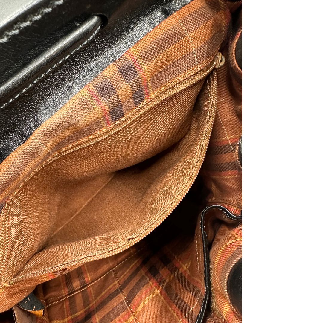 Interno di uno zaino The Bridge in cuoio nero con parti metalliche argentate. Cinghie delle bretelle regolabili. Completo di dustbag.